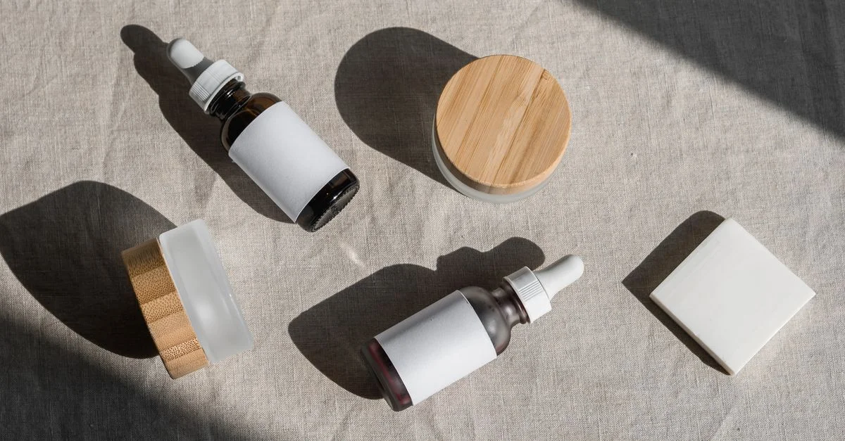 Une mise en scène minimaliste de bouteilles et de pots cosmétiques sur un linge en lin, parfaite pour des présentations de produits de beauté.