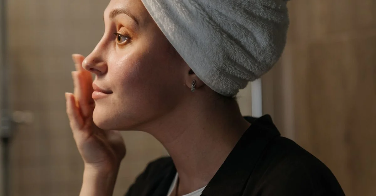 Une femme appliquant des soins de la peau pour une routine de peau radieuse.