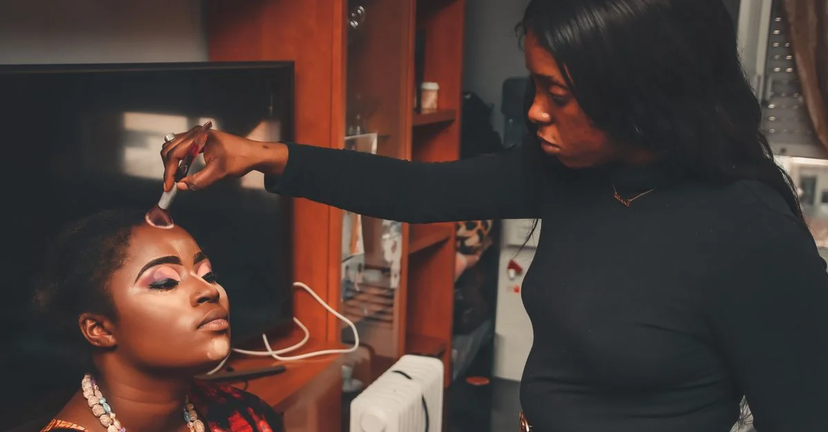Une maquilleuse applique habilement du maquillage à une femme, rehaussant sa beauté à l'intérieur.